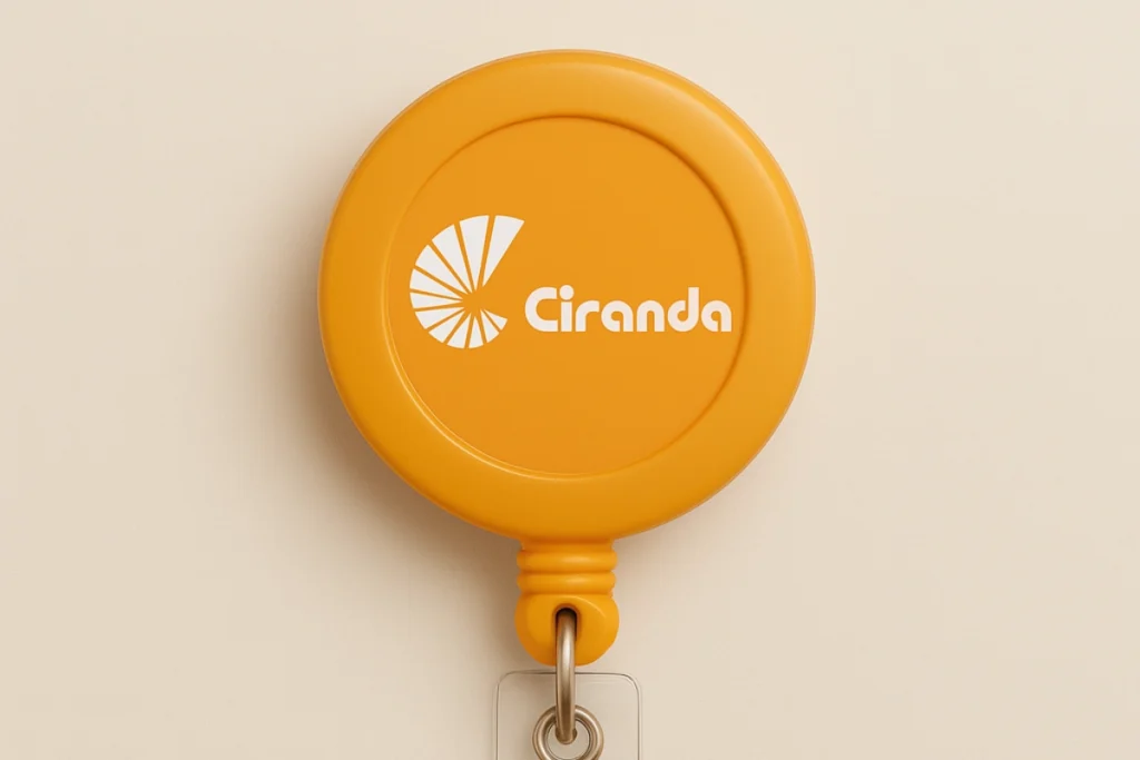 Roller clip laranja com o logotipo do Colégio Ciranda, ideal para identificação escolar com crachá personalizado.