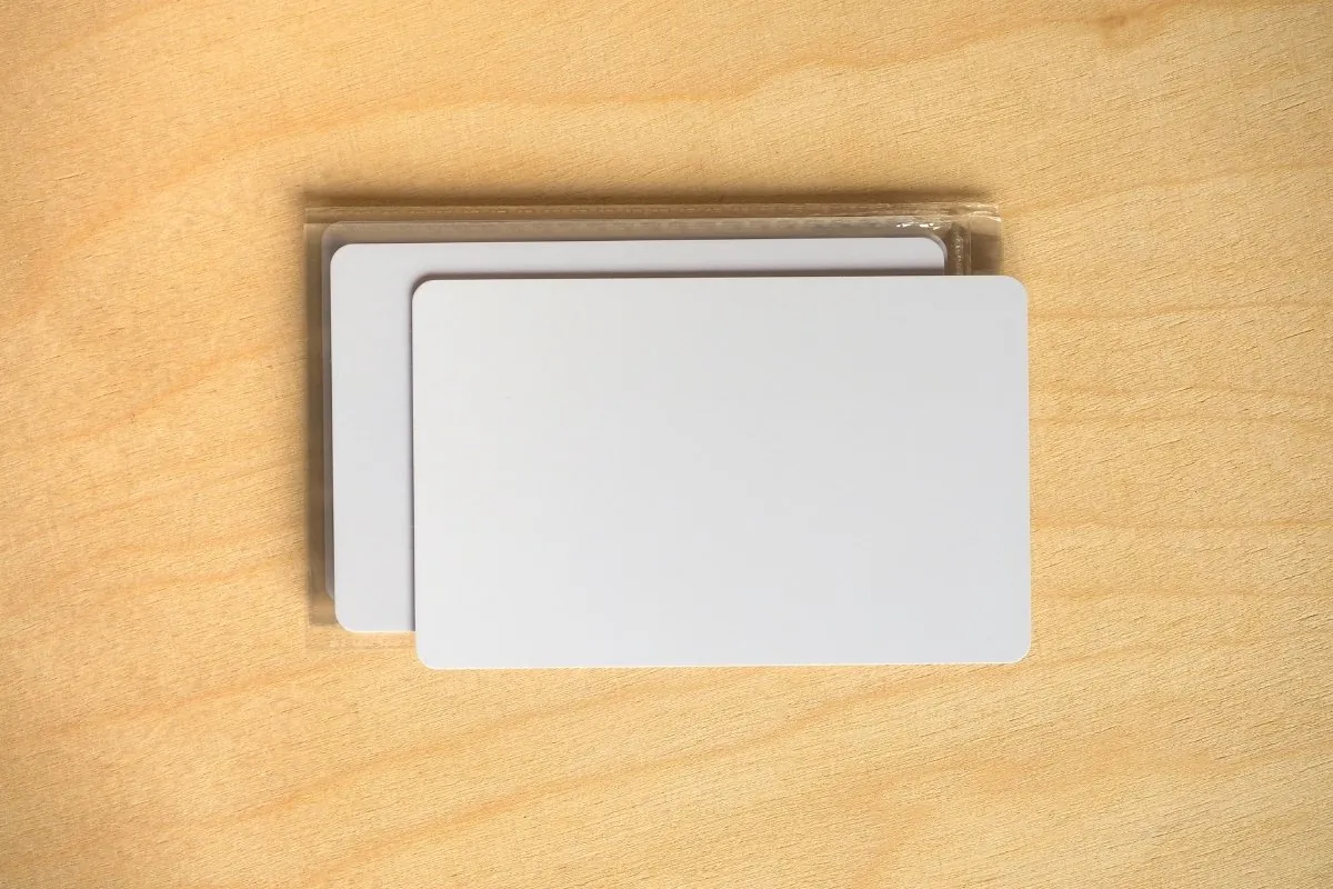 Cartões RFID para Identificação | Campinas 8 Cartões PVC brancos sem impressão sobre mesa de madeira, prontos para personalização